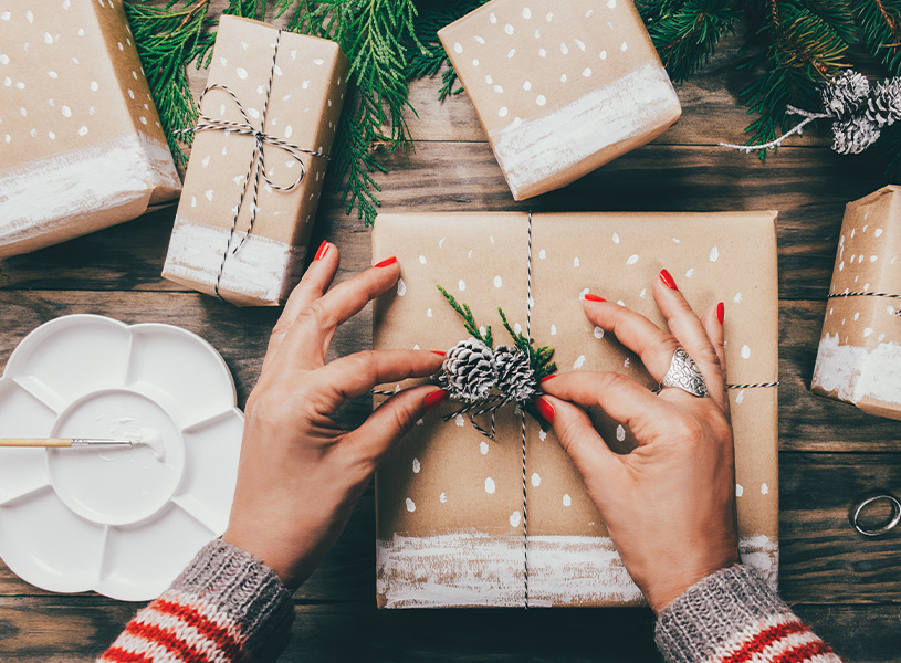 Eine Frau dekoriert eine Weihnachtsgeschenkschachtel